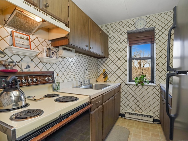 kitchen featuring visible vents, range with electric cooktop, under cabinet range hood, a sink, and freestanding refrigerator