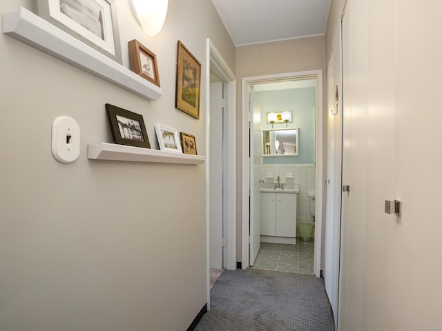 hall with tile walls and carpet