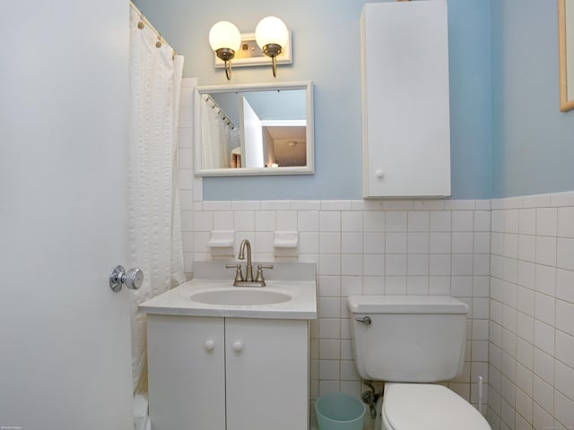 bathroom featuring toilet, tile walls, and vanity