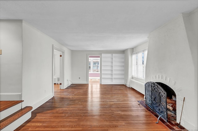 living area with a wealth of natural light, radiator, and wood finished floors