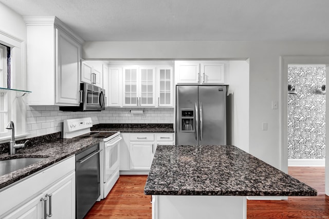 kitchen featuring decorative backsplash, wood finished floors, appliances with stainless steel finishes, and a sink