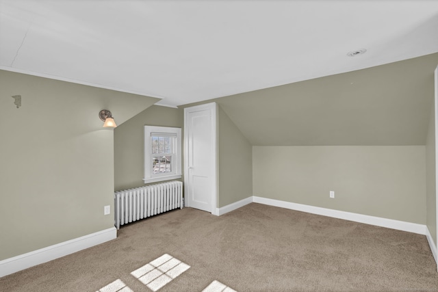 bonus room featuring baseboards, radiator, and carpet