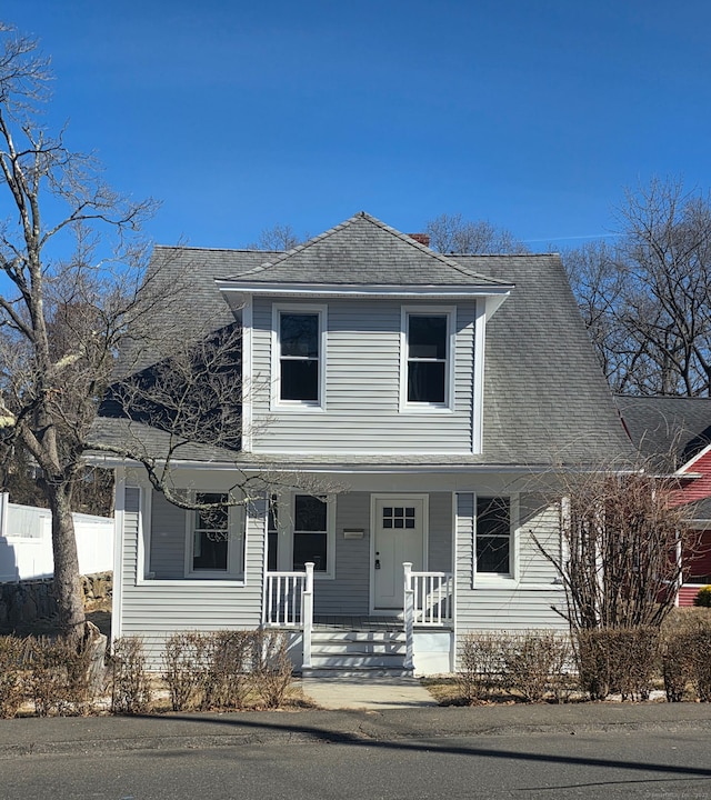 traditional-style house featuring covered porch and a shingled roof