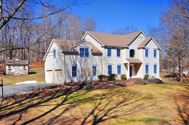 view of front of property featuring driveway, an attached garage, and a front yard