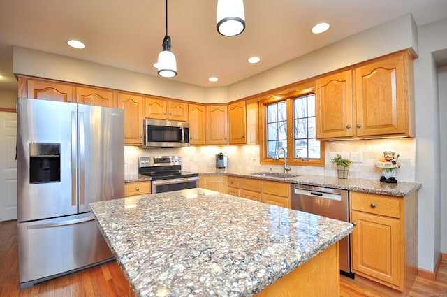 kitchen with light stone counters, appliances with stainless steel finishes, and a sink