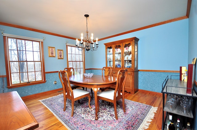 dining room with wallpapered walls, a notable chandelier, a wainscoted wall, and a wealth of natural light