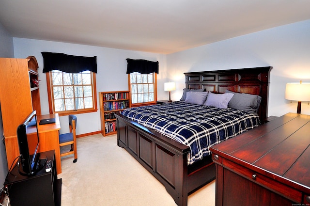 bedroom featuring light colored carpet and baseboards