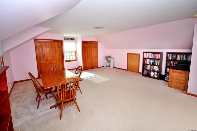 dining area featuring carpet floors, baseboards, and vaulted ceiling