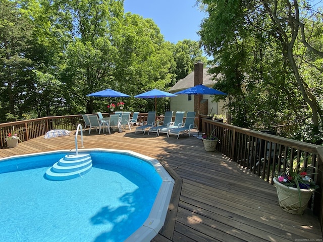 view of swimming pool featuring outdoor dining area and a wooden deck