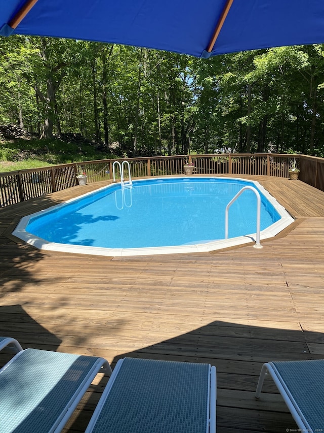 view of swimming pool featuring a deck and a fenced in pool