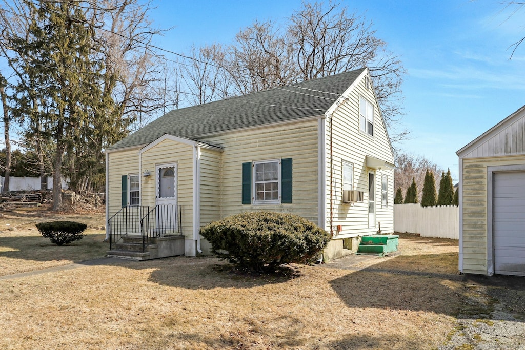 view of front of house with a shingled roof and fence