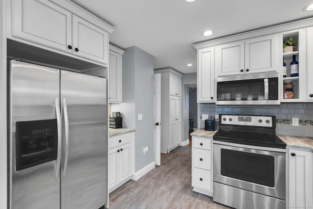 kitchen featuring recessed lighting, tasteful backsplash, appliances with stainless steel finishes, and light wood finished floors