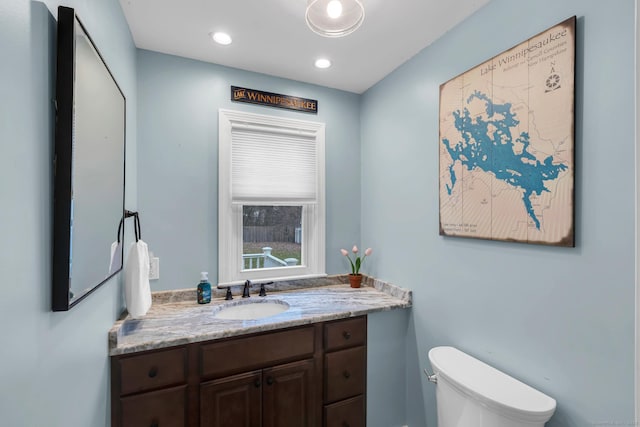 bathroom with vanity, toilet, and recessed lighting