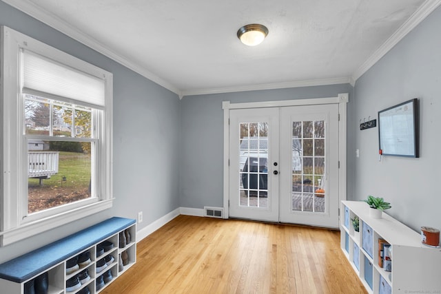 doorway with visible vents, baseboards, ornamental molding, french doors, and wood finished floors