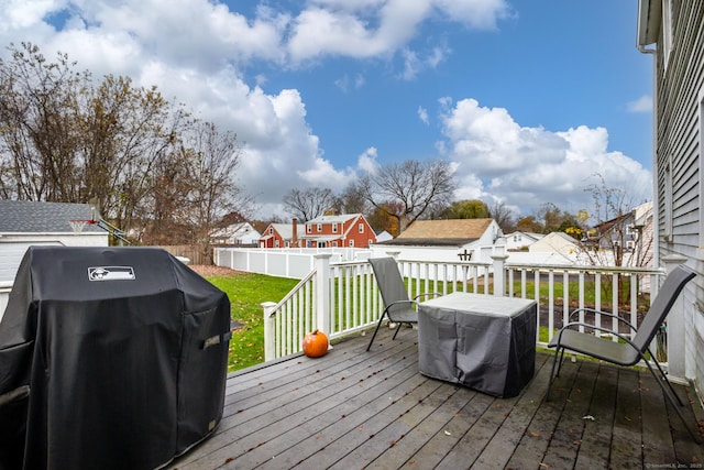 deck with a residential view, a lawn, a grill, and a fenced backyard