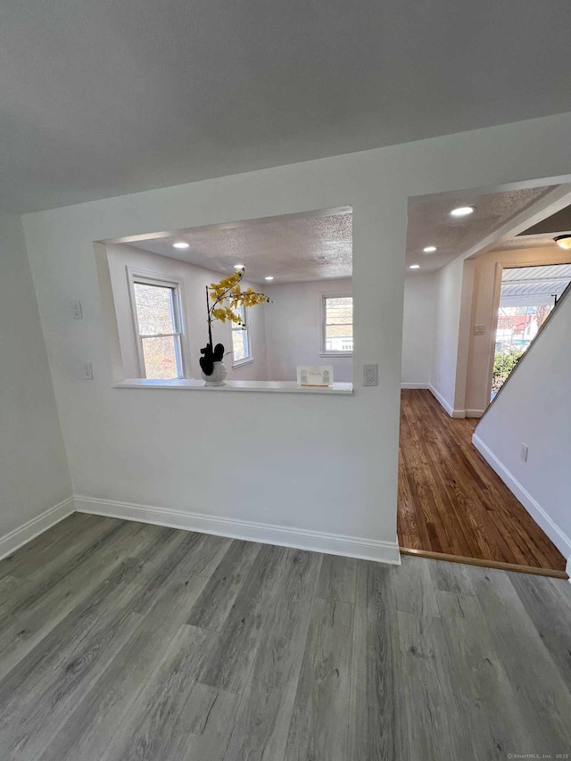 interior space with a wealth of natural light, baseboards, and wood finished floors