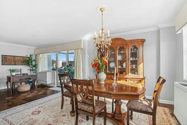 dining room featuring a notable chandelier, baseboards, and ornamental molding