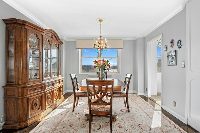 dining area featuring baseboards, an inviting chandelier, and ornamental molding