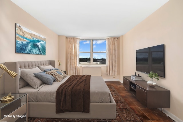 bedroom with baseboards and dark wood-style flooring