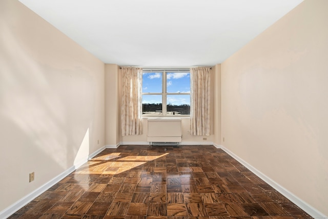 unfurnished room with baseboards