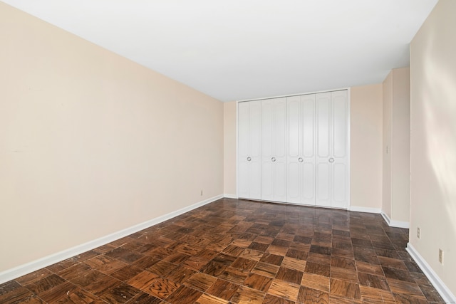 unfurnished bedroom with a closet and baseboards