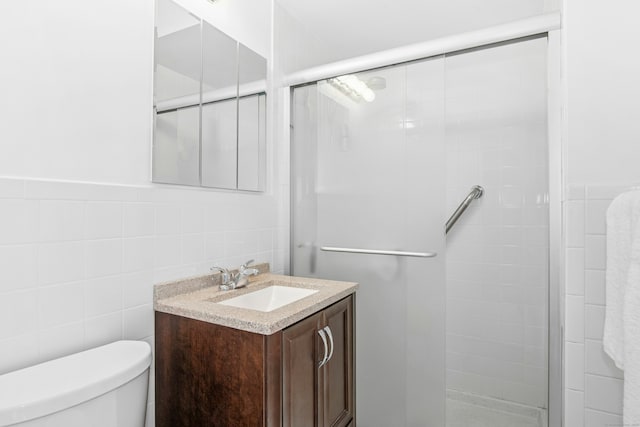 bathroom with toilet, a stall shower, and tile walls