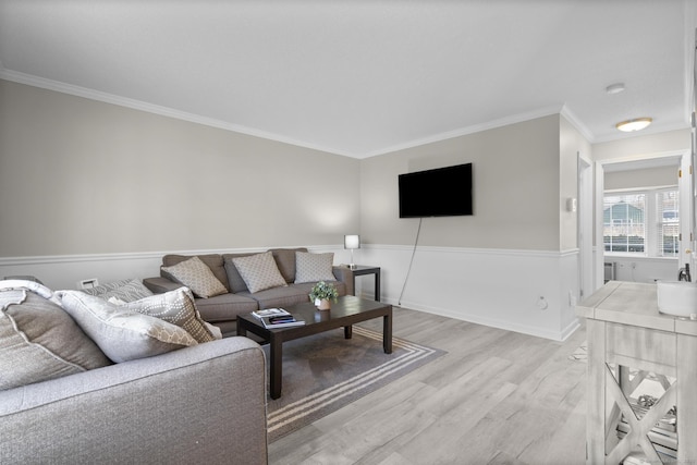 living area featuring crown molding, wood finished floors, and baseboards