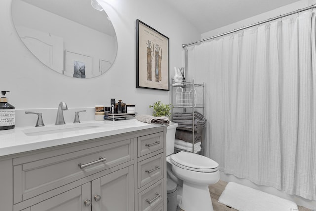 bathroom with toilet, wood finished floors, and vanity