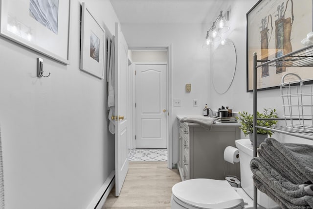 bathroom with toilet, wood finished floors, and vanity