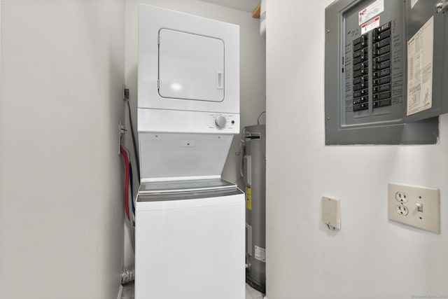 clothes washing area featuring electric panel, water heater, laundry area, and stacked washing maching and dryer