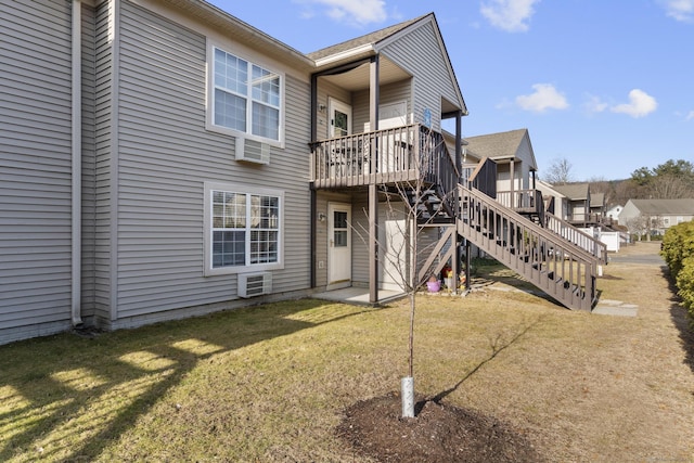 rear view of house with a deck, stairs, and a yard