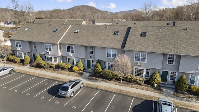 view of property with a mountain view and uncovered parking