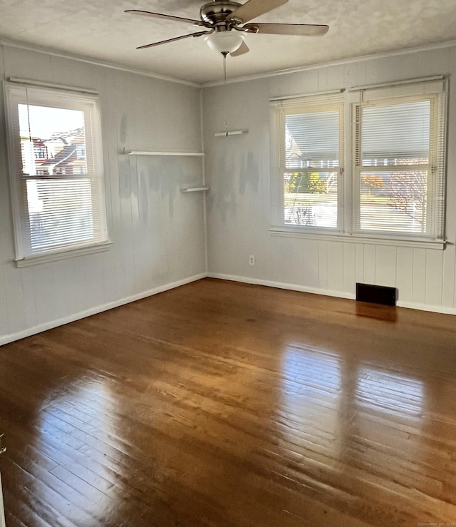 unfurnished room with baseboards, hardwood / wood-style flooring, ceiling fan, and ornamental molding