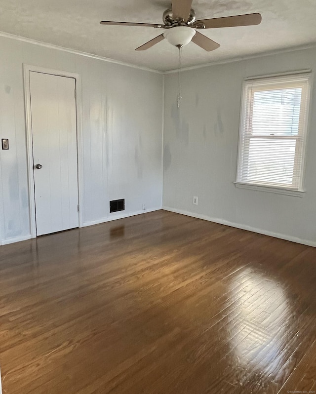 spare room featuring visible vents, a ceiling fan, wood finished floors, and crown molding