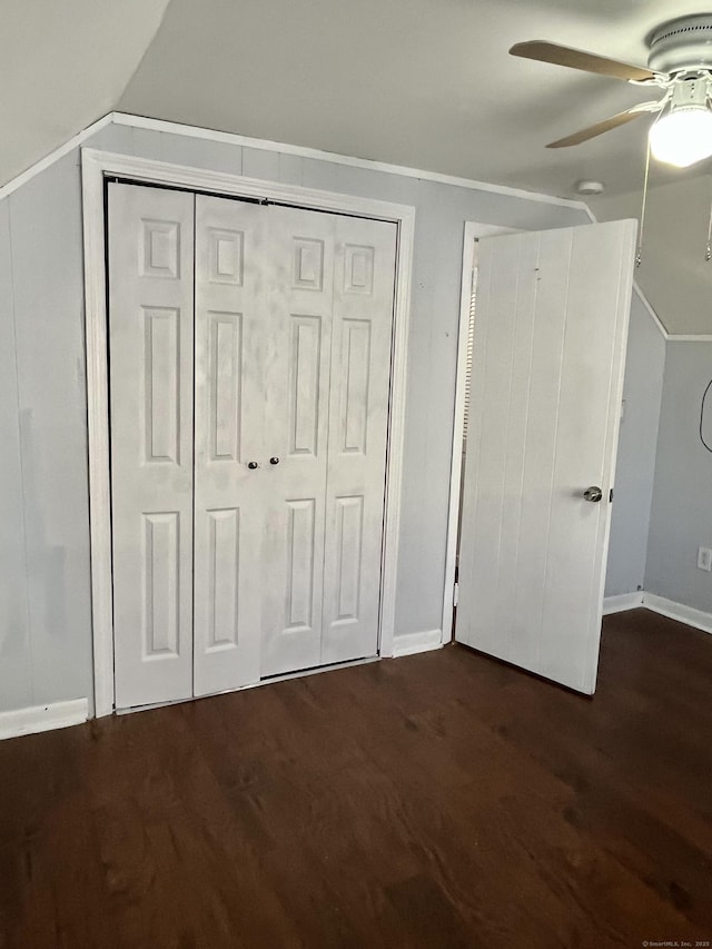 unfurnished bedroom featuring a closet, ceiling fan, lofted ceiling, and wood finished floors