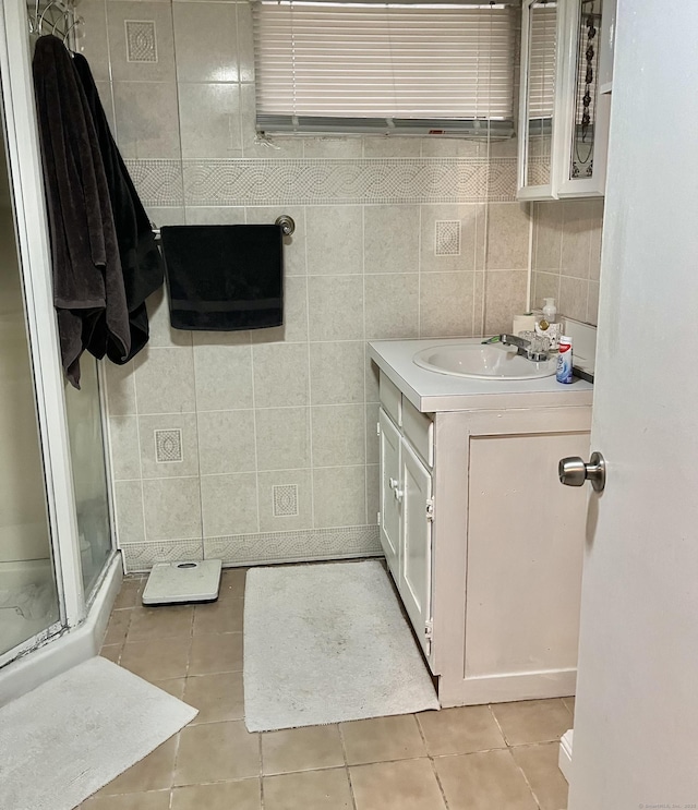 bathroom featuring vanity, tile walls, a shower stall, and tile patterned flooring