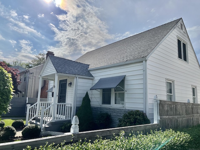 84 Glendale Ave, Bridgeport, CT 06606 - view of front facade featuring fence, roof with shingles, and stone siding