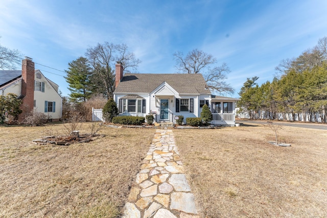 view of front of property with a front yard, a chimney, and fence