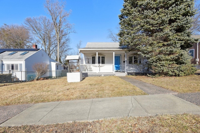 view of front of house featuring a porch, fence, and a front yard