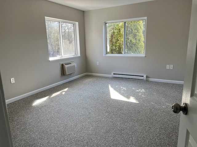 spare room with a wall unit AC, carpet flooring, a wealth of natural light, and a baseboard radiator