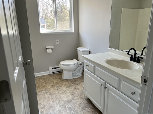 bathroom featuring a baseboard heating unit, toilet, vanity, and baseboards