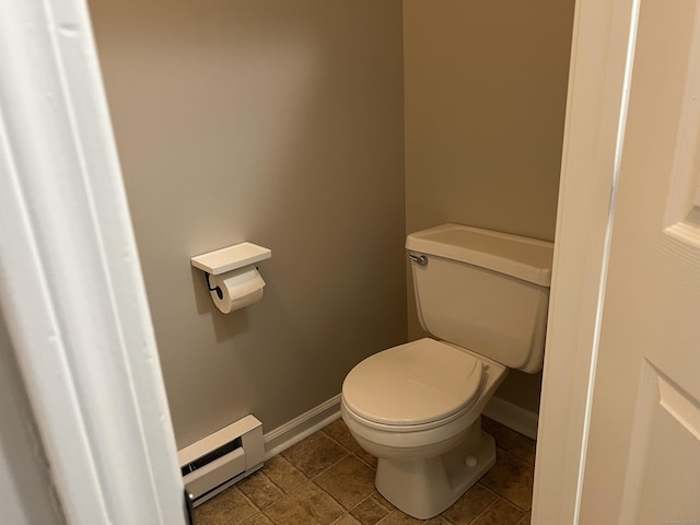 bathroom with tile patterned floors, baseboards, baseboard heating, and toilet