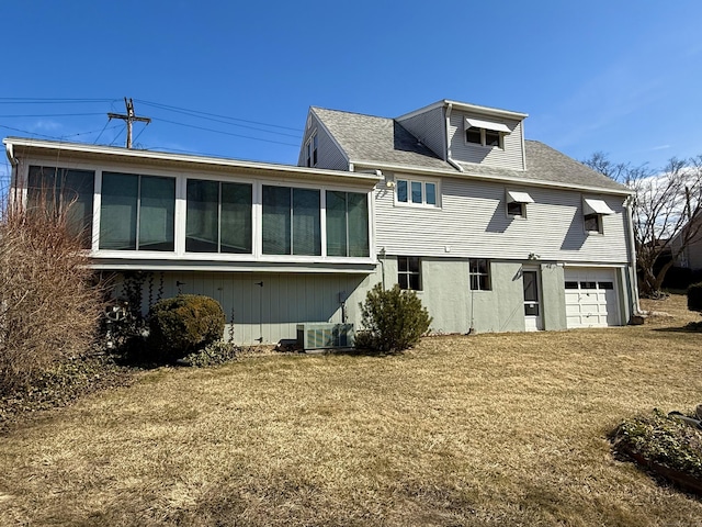 back of property featuring a sunroom, cooling unit, and an attached garage