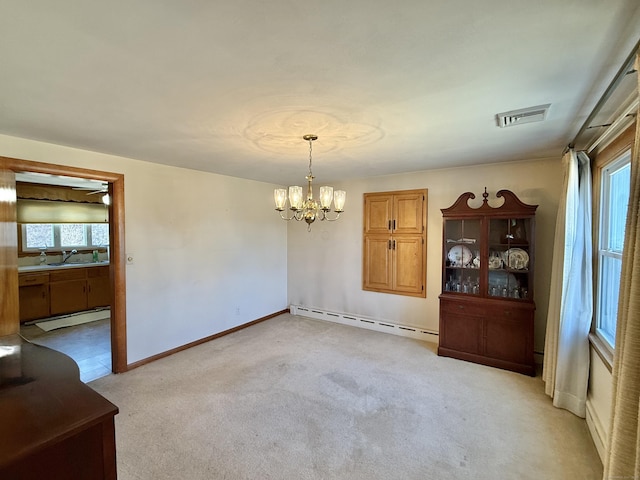 unfurnished dining area with a chandelier, visible vents, a sink, and a baseboard radiator