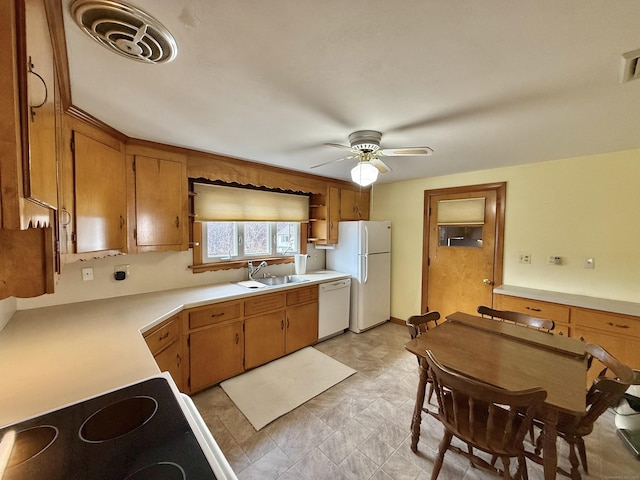 kitchen featuring white appliances, a ceiling fan, visible vents, a sink, and light countertops