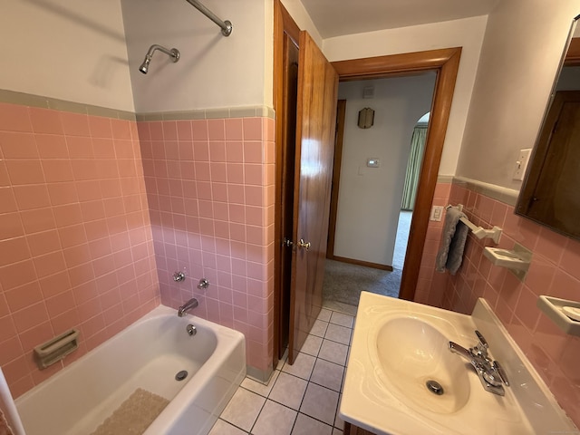 bathroom featuring tile patterned floors, shower / bathing tub combination, tile walls, wainscoting, and vanity