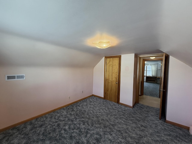 additional living space with visible vents, carpet floors, baseboards, and vaulted ceiling