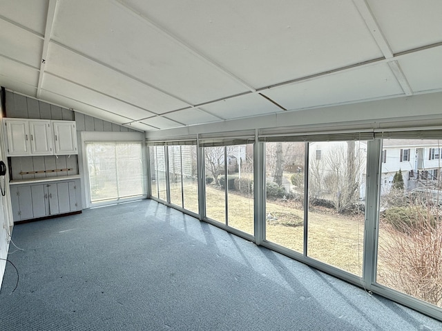 unfurnished sunroom featuring a healthy amount of sunlight and vaulted ceiling