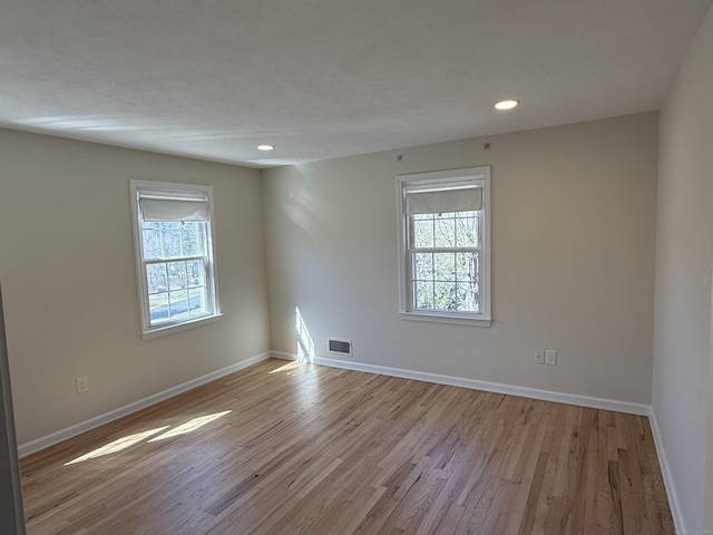 unfurnished room with visible vents, recessed lighting, baseboards, and light wood-style floors