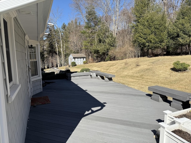 deck featuring a storage unit, an outbuilding, and a lawn